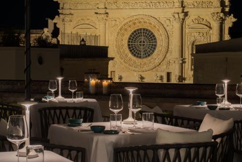 a group of tables with wine glasses in a restaurant at Patria Palace Lecce - The Leading Hotels of The World in Lecce