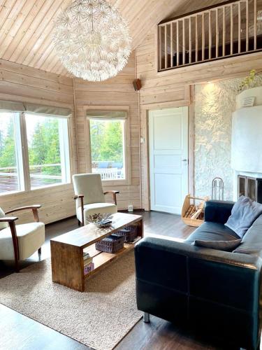 a living room with a blue couch and a chandelier at Hietavilla Borealis in Ruka