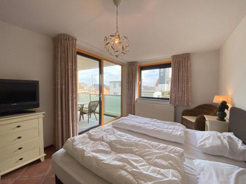 a bedroom with a bed and a tv and a window at Callantsoger Staete A109 in Callantsoog