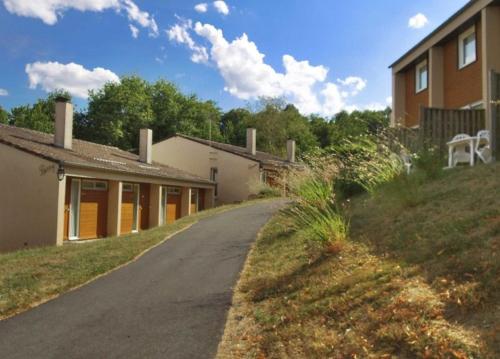 a road next to a building with a house at VVF Lac d'Eguzon in Éguzon-Chantôme