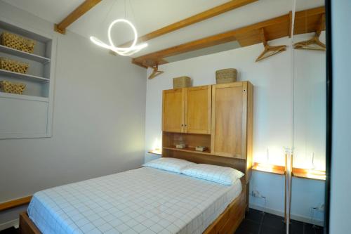 Schlafzimmer mit einem Bett und einem Holzschrank in der Unterkunft Albero Maestro on Bussana seaside in Sanremo