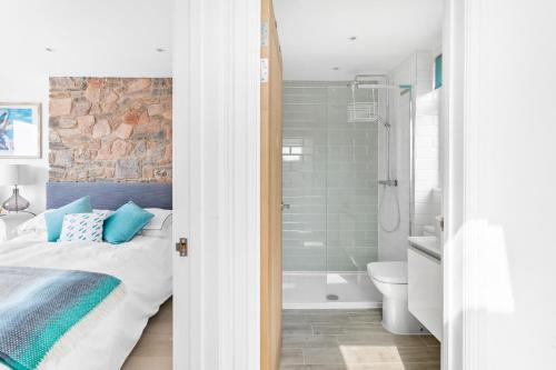 a bedroom with a bed and a bathroom with a shower at The Captain's Cottage, Brixham in Brixham