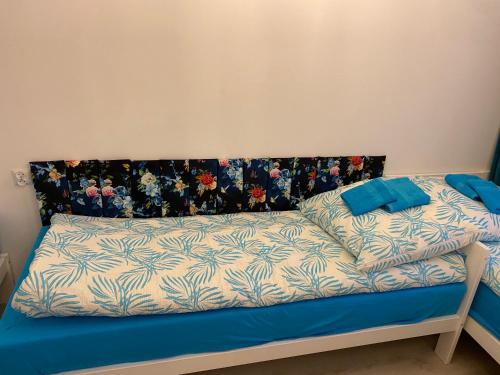 a bed with a blue and white comforter on it at Turkusowy Zakątek Głogów in Głogów