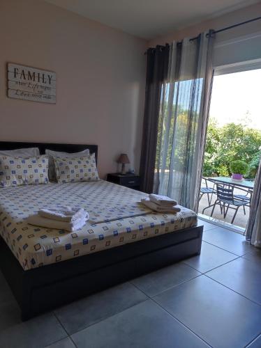 a bedroom with a bed with a view of a patio at PHOENIX apartment near the airport in Markopoulo