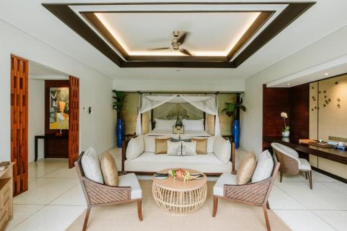 a bedroom with a bed and a table and chairs at The Samaya Seminyak Bali in Seminyak