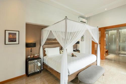 a bedroom with a white bed with a canopy at The Samaya Seminyak Bali in Seminyak