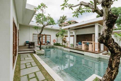 a house with a swimming pool and a tree at The Samaya Seminyak Bali in Seminyak