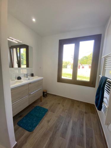 une salle de bain avec un lavabo et une grande fenêtre dans l'établissement Logement calme et confortable au cœur de Loupiac, à Loupiac-de-Cadillac