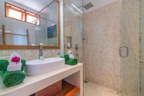 y baño con bañera, ducha y lavamanos. en Villa Mata Hari, en Panji