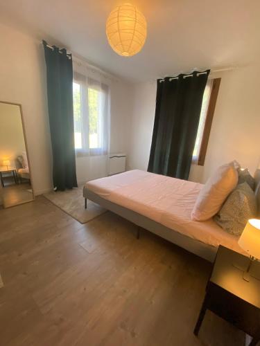 une chambre avec un grand lit dans une pièce dans l'établissement Logement calme et confortable au cœur de Loupiac, à Loupiac-de-Cadillac