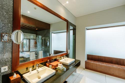 ein Badezimmer mit zwei Waschbecken und einem Spiegel in der Unterkunft The Samaya Seminyak Bali in Seminyak