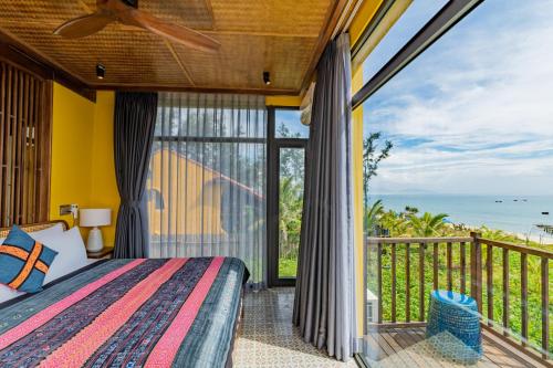 a bedroom with a bed and a balcony with the ocean at May Villa 6BR Beachfront An Bang Beach Hoi An by Beachside Boutique Homes in An Bàn (2)