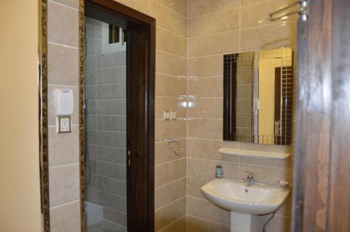 ein Bad mit einem Waschbecken und einem Spiegel in der Unterkunft شقق البحر الازرق المخدومة in Bisha