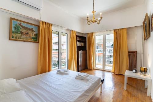 1 dormitorio con 1 cama blanca grande y ventanas en Pagrati 2 bedrooms 5 persons apartment by MPS, en Atenas