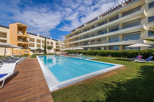 a swimming pool in front of a building at Laguna - Vilamoura in Vilamoura