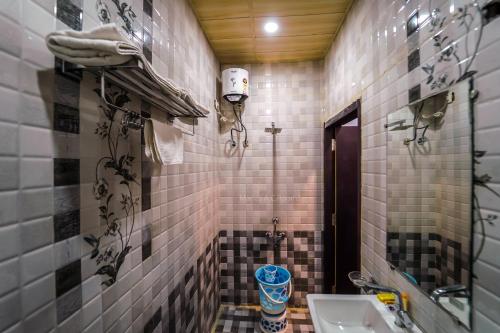 La petite salle de bains est pourvue d'un lavabo et de toilettes. dans l'établissement Manas AC Rooms, à Ratlām