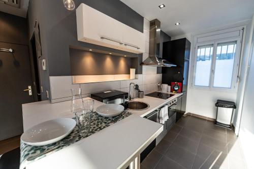 une cuisine avec comptoirs blancs et comptoir dans l'établissement Théa : Studio avec parking privé - Actif+ Location-, à Marseille