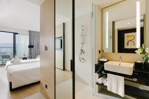 a bathroom with a sink and a bed and a mirror at December Hotel in Nha Trang