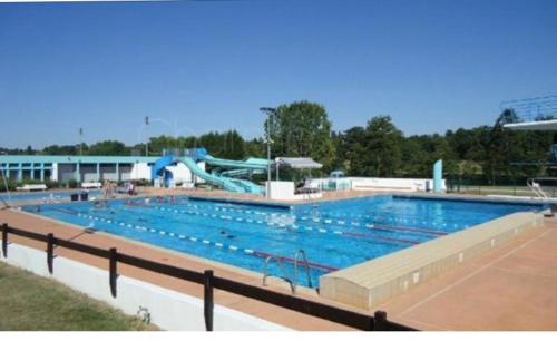 une grande piscine avec un toboggan aquatique dans l'établissement Gîte des Lavandes, à Oradour-Fanais