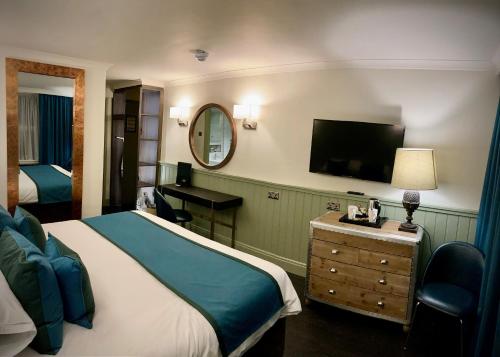a hotel room with a bed and a flat screen tv at Blackwell Grange Hotel in Darlington