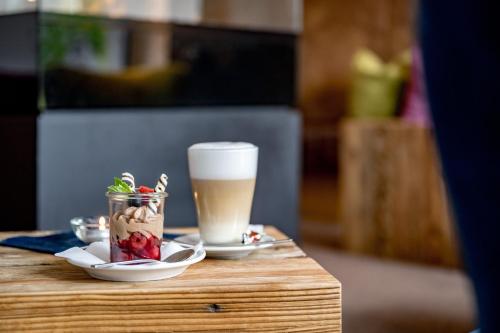 a table with a cup of coffee and a drink at Hotel Zum Gourmet in Seefeld in Tirol