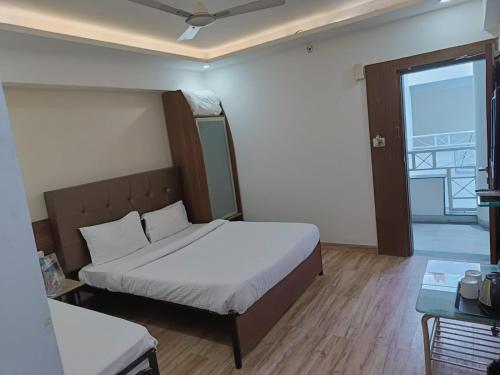 a small bedroom with a bed and a window at Alba Premier, Indore in Indore