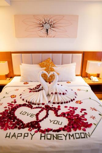 a bed with a swan and flowers on it at The Sun Hotel & Spa Legian in Legian