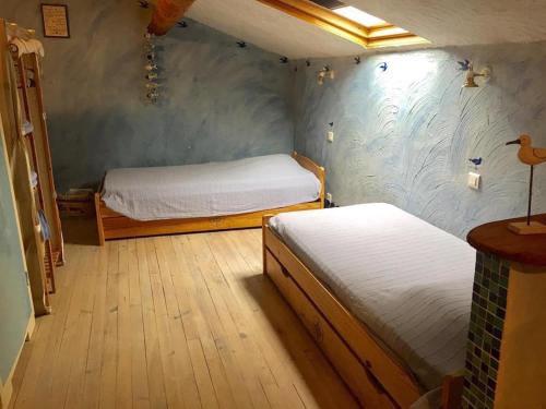 Gîte Le Roucoul في Maraussan: غرفة صغيرة بسريرين في غرفة