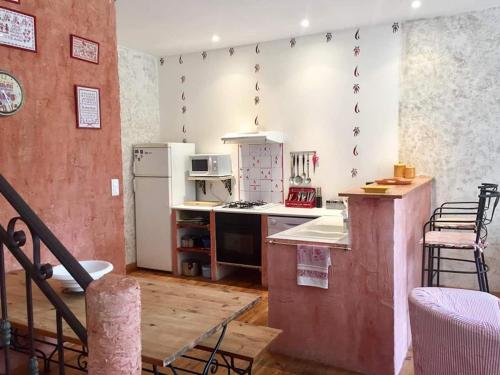 a kitchen with a stove and a refrigerator at Gîte Le Roucoul in Maraussan