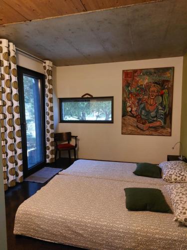 モスト・ナ・ソシにあるHoliday Home Hisa Gustaのベッドルーム1室(ベッド2台付)が備わります。壁には絵画が飾られています。