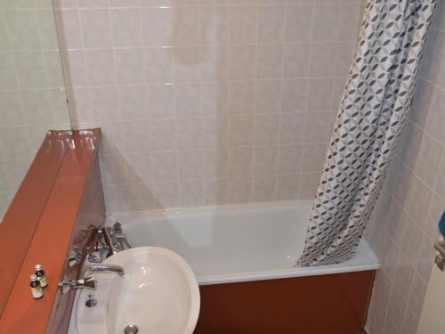 une salle de bain avec un lavabo et une baignoire dans l'établissement Appartement cosy 2 pièces au pied des pistes, parking et casier à skis - FR-1-266-62, à Montgenèvre