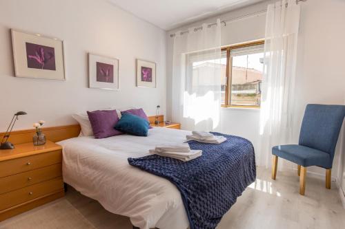 1 dormitorio con 1 cama y 1 silla azul en Metro Lapa House with sunny balcony and A/C, en Oporto