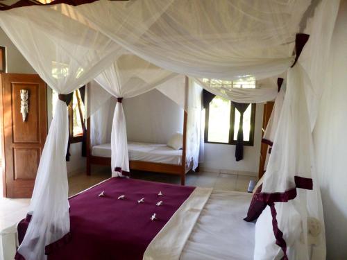 a bedroom with a bed with a canopy at Bali Oase Resort in Pemuteran
