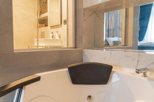 a bathroom with a bath tub with a black seat at 9 Nine - Luxury Apartments & Suites in Belgrade