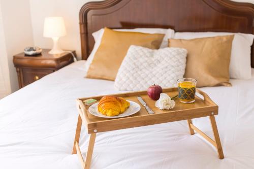 bandeja con un plato de comida en la cama en Metro Lapa House with sunny balcony and A/C, en Oporto