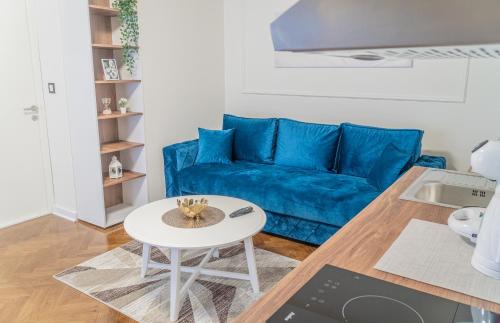 a living room with a blue couch and a table at 9 Nine - Luxury Apartments & Suites in Belgrade