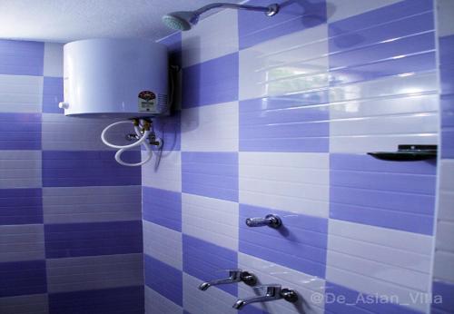a blue and white bathroom with two faucets at De Asian Villa Pondicherry in Auroville