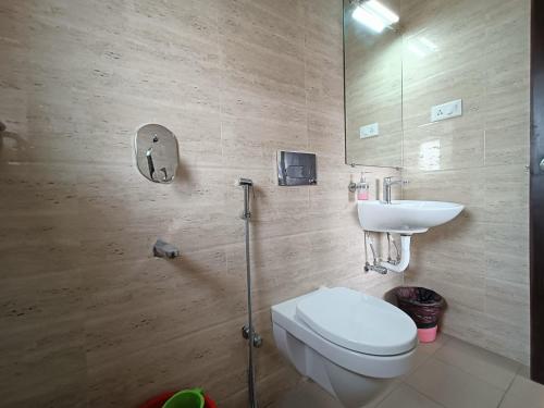 a bathroom with a toilet and a sink at Sheldon Inn Kolkata in Kolkata