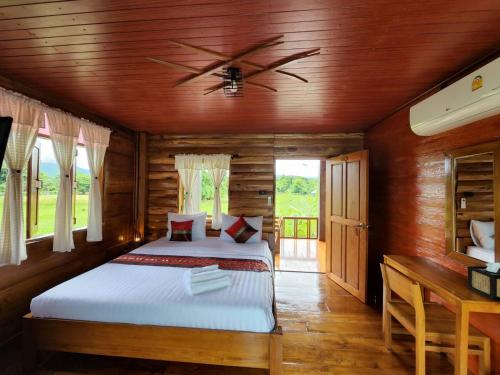 Chill House Mae Sariang في Ban Mae Salap: غرفة نوم بسرير وسقف خشبي