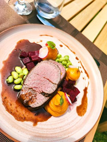 a plate of food with meat and vegetables on a table at 3 Stejari Brasov in Braşov