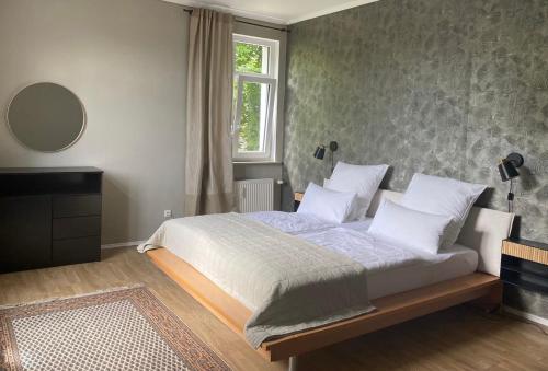 a bedroom with a bed with white pillows and a window at Stadtvilla Hameln in Hameln