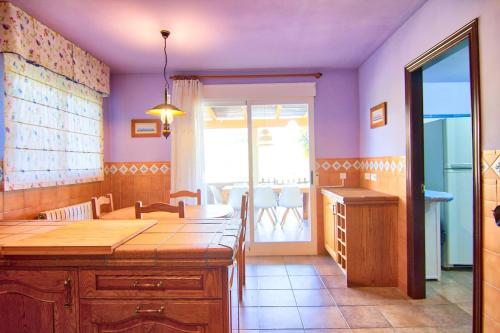 a kitchen with purple walls and a sink and a table at Villa Los Olivos in Peniscola