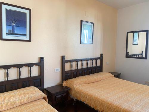 Habitación de hotel con 2 camas y 2 espejos en Apartamentos Mar de Peñíscola Casablanca 3000, en Peñíscola