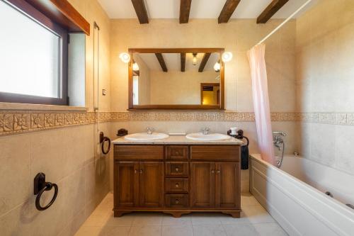 a bathroom with two sinks and a tub and a mirror at Villa Junceira - refúgio de luxo perto do Castelo in Óbidos