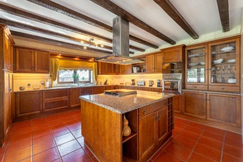 a kitchen with wooden cabinets and a large island at Villa Junceira in Óbidos