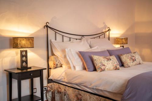a bedroom with a bed with pillows and two lamps at Villa Junceira in Óbidos