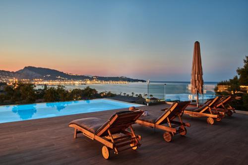 a group of chairs sitting next to a swimming pool at Althea Lavish Estate - Villa & Suite in Zakynthos Town