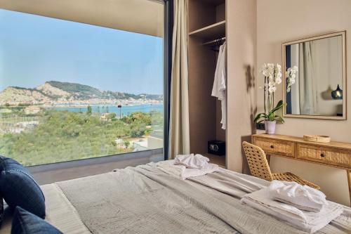 a bedroom with a bed and a large window at Althea Lavish Estate - Villa & Suite in Zakynthos Town