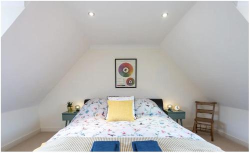 een slaapkamer met een bed en 2 tafels en een stoel bij Wells City Centre, Quiet Mews House, sleeps 6 in Wells