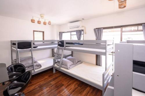 a room with two bunk beds and a table and chairs at G’Day Senbayashi in Osaka